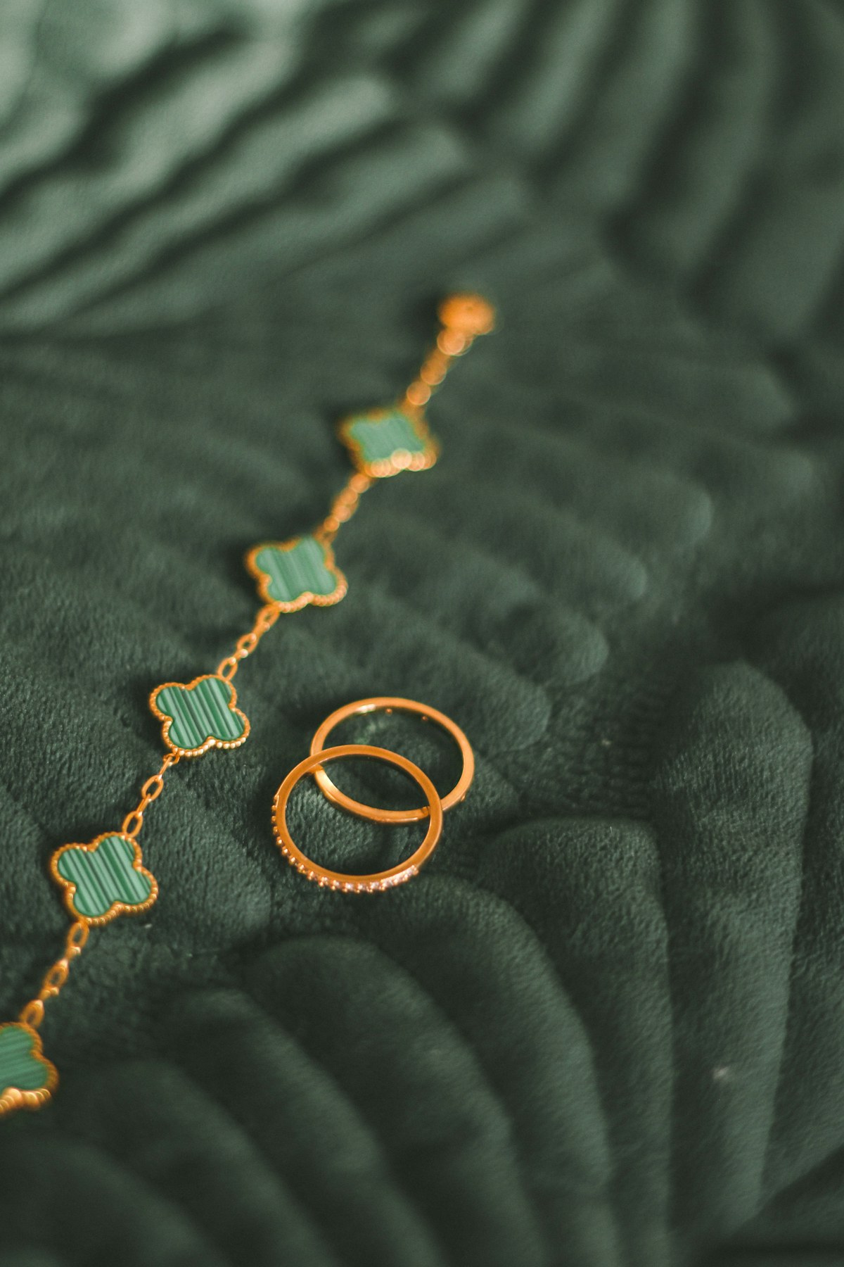 Goldringe und goldene Kette auf dunklem Stoff